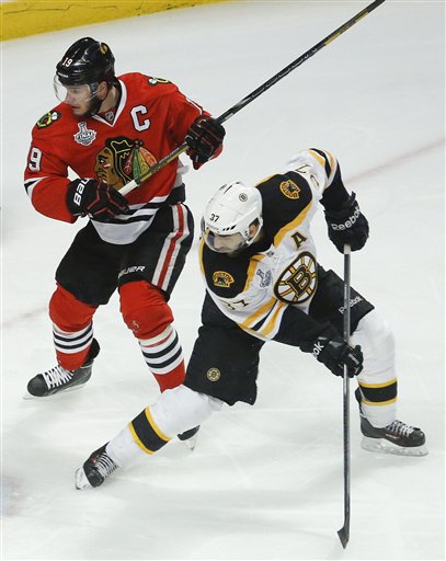 Boston Bruins center Patrice Bergeron (37) looks for a rebound against Chicago Blackhawks center Jonathan Toews (19) in the first period during Game 5 of the Stanley Cup Finals on Saturday in Chicago. Bergeron and Toews are both injured entering Game 6 on Monday.