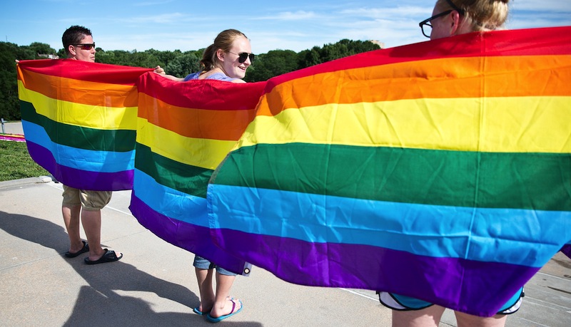 From left, Mel Shartrand, Maddyson Maddox and Makayla Maddox hold up gay rights flags during a gathering at Memorial Park to celebrate the Supreme Court rulings on gay marriage on Wednesday, June 26, 2013. (AP Photo/The World-Herald, ) DOMA;MEMORIAL PARK;OMAHA;NEBRASKA;SUPREME COURT