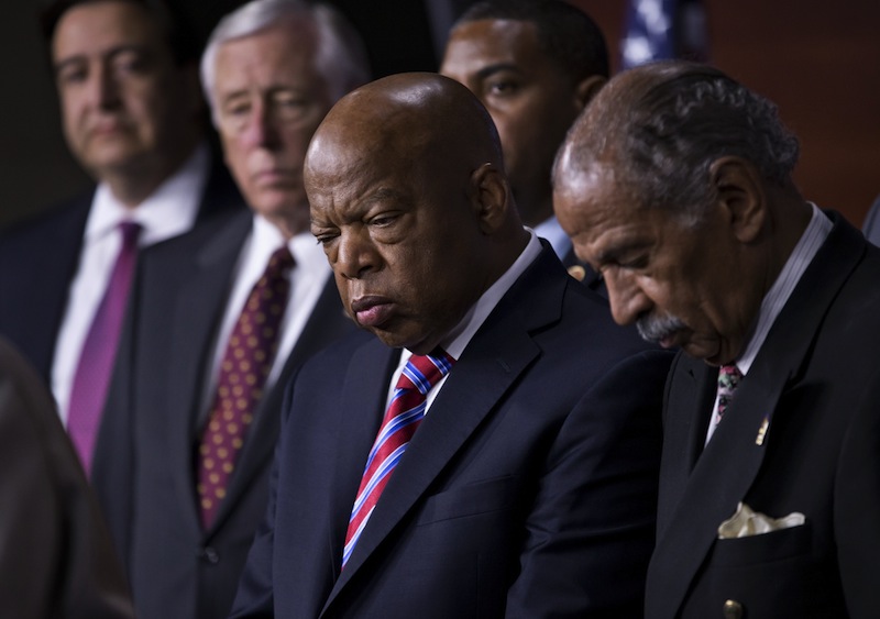 Rep. John Lewis, D-Ga., center, and Rep. John Conyers, D-Mich., right, co-chairs of the Civil Rights Taskforce of the Congressional Black Caucus, join other members of the House to express disappointment in the Supreme Court's decision on Shelby County v. Holder that invalidates Section 4 of the Voting Rights Act, Tuesday, June 25, 2013, on Capitol Hill in Washington. Lewis, a prominent activist in the Civil Rights Movement in the 1960's, recalled being attacked and beaten trying to help people in Mississippi to register and vote in the 1960's. (AP Photo/J. Scott Applewhite)