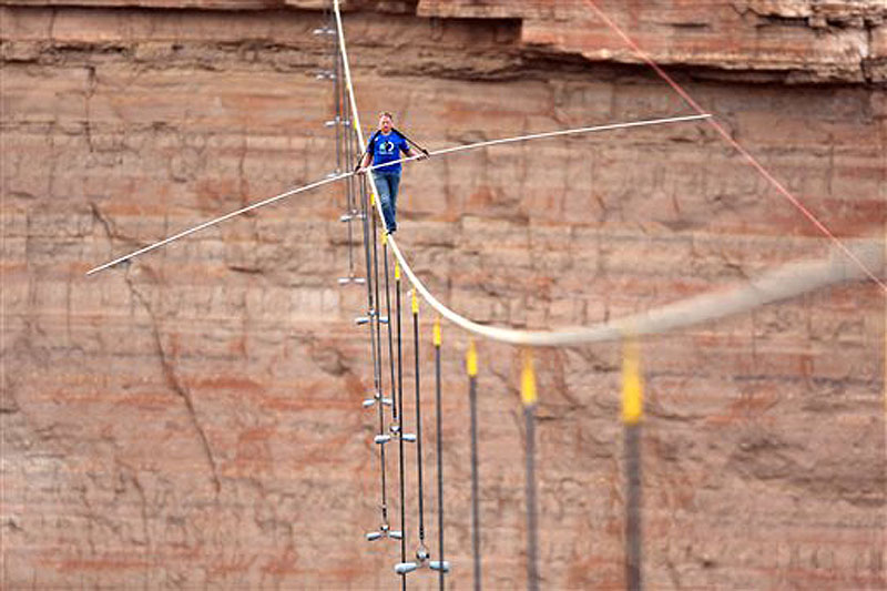 Aerialist Nik Wallenda walks a 2-inch-thick steel cable taking him a quarter mile over the Little Colorado River Gorge, Ariz. The daredevil successfully traversed the tightrope strung 1,500 feet above the chasm near the Grand Canyon in just more than 22 minutes, pausing and crouching twice as winds whipped around him and the cable swayed.