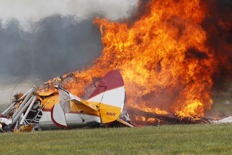 Flames erupt from a plane after it crashed at the Vectren Air Show at the airport in Dayton, Ohio, on Saturday. The crash killed the pilot and stunt walker on the plane instantly, authorities said.