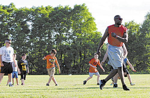 RUNNING THE DRILL: Former New England Patriots player Eric Alexander runs a conditioning drill at the annual Central Maine Football Clinic on Friday night in Waterville. The clinic will continue from 9 a.m. to 3 p.m. today at Rummel Field off West River Road.