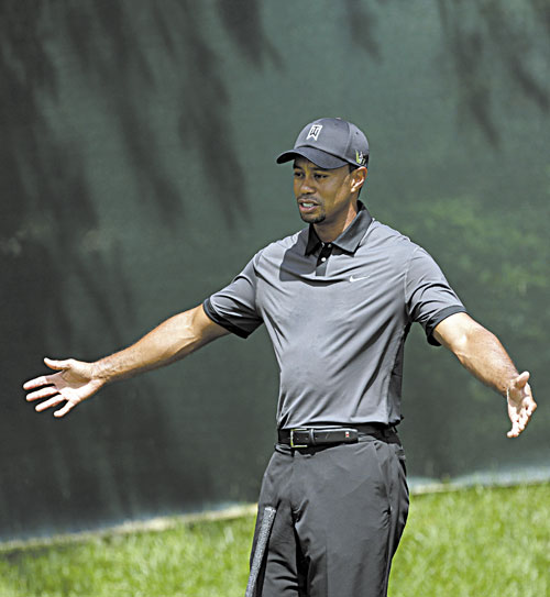 READY TO GO: Tiger Woods talks with a coach on the practice green during a practice for the U.S. Open on Tuesday at Merion Golf Club in Ardmore, Pa.