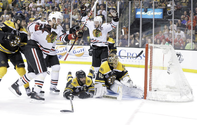HEART-BREAKING GOAL: Chicago Blackhawks left wing Bryan Bickell, left, celebrates his goal against the Boston Bruins, with Blackhawks center Jonathan Toews, center, as Bruins defenseman Zdeno Chara (33) and goalie Tuukka Rask (40) watch the puck in the goal during the third period of Game 6 of the Stanley Cup finals on Monday in Boston. Chicago scored two goals in 17 seconds, the second with less than a minute to go, to beat the Bruins 3-2 and win the Stanley Cup. TD Garden