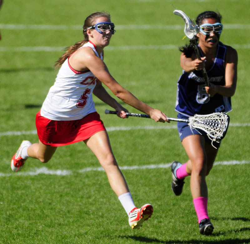 A GOAL: Cony’s Emily Quirion, left, follows through on a shot which Portland defender Quinn Lavigne tries to stop during the Rams’ 12-8 win in an Eastern A quarterfinal Wednesday in Augusta.
