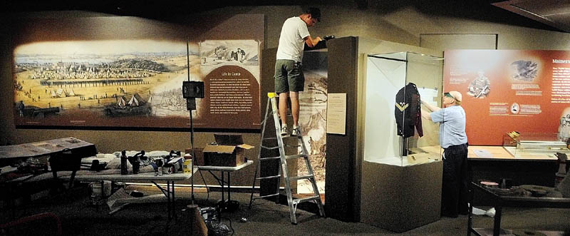 James Flachsbart, left, and Don Bassett work on the exhibit titled "Maine Voices from the Civil War" on Wednesday at the Maine State Museum in Augusta.