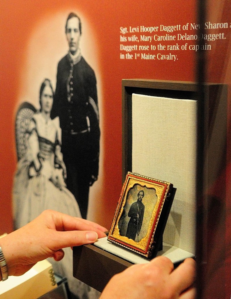 Conservation specialist Linda Carrell positions a photograph in a display case of an exhibit titled "Maine Voices from the Civil War," on Wednesday at the Maine State Museum in Augusta.