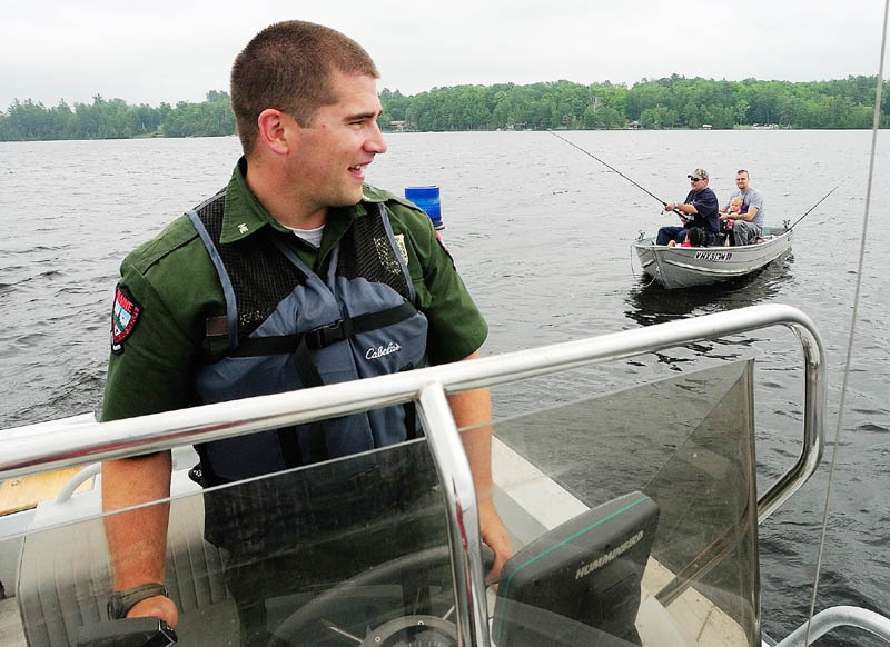 Deputy Game Warden Harry Wiegman pulls away after checking on two men and two children fishing on Wednesday on Messalonskee Lake in Sidney.