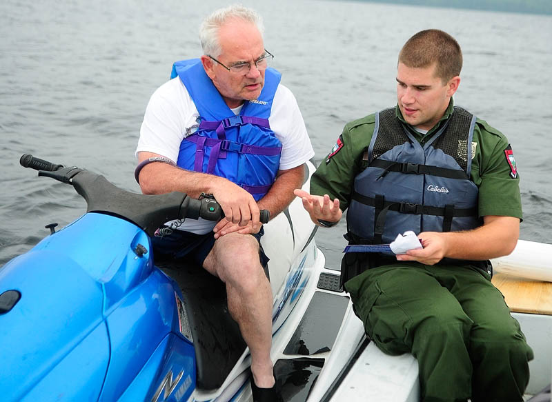 Deputy Game Warden Harry Wiegman, right, talks to Frank Card while doing a safety check.