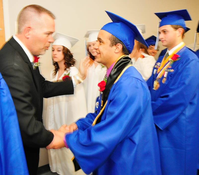 Associate Headmaster Jamie Soule, left, shakes hands with Jaun Cosme before Erskine Academy's commencement on Friday at the Augusta Civic Center.