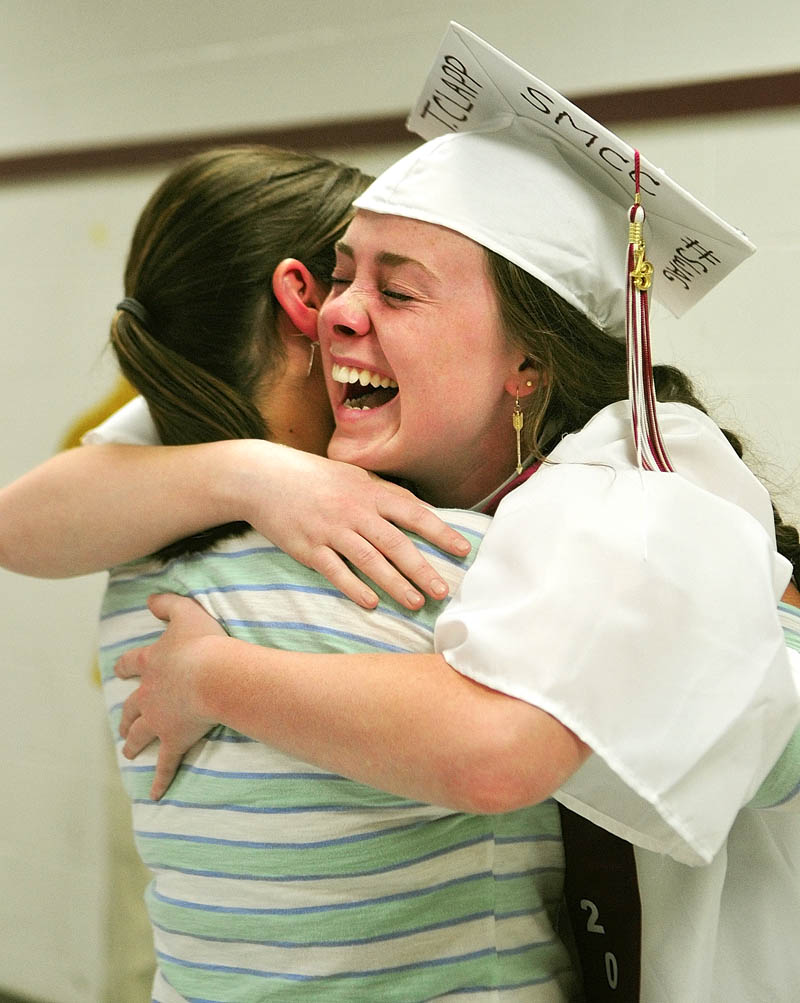 Senior Taylor Clapp, left, hugs her old friend, Sarah Spofford, of Greenfield, Mass., who surprised her by showing up at her graduation ceremony on Saturday at Richmond High School.