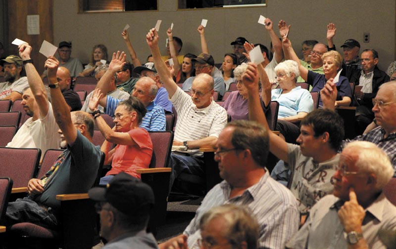 Farmingdale residents vote to continue the discussion of Article 10 at the annual town meeting at Hall-Dale Middle School on Saturday.