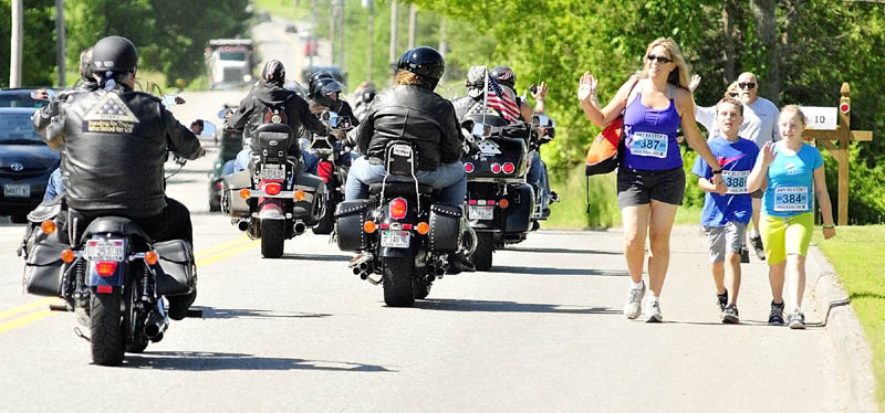 A group of motorcyclists, cruising to VA Maine Healthcare Systems-Togus for the 12th Annual Togus Veterans Car Show, and walkers, taking part in the Amy Buxton's Underdog Jog Memorial 5K Run and Walk, wave at each other as they cross pathes on Cony Road on Saturday in Augusta. Proceeds from the run/walk event, which began and ended at Cony High School, were to benefit Almost Home Rescue, the Kennebec Valley Humane Society and the Family Violence Project.