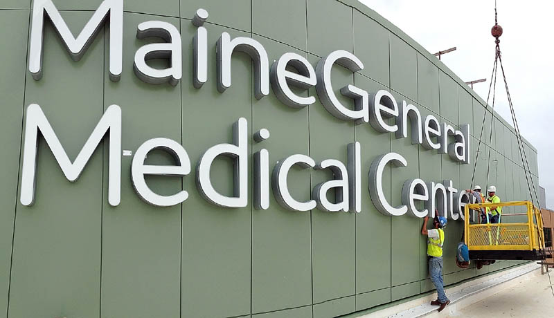 Workers clean the walls around the recently mounted sign letters on top of the Alfond Center for Health regional hospital, to be operated by MaineGeneral Health, on Wednesday in Augusta.
