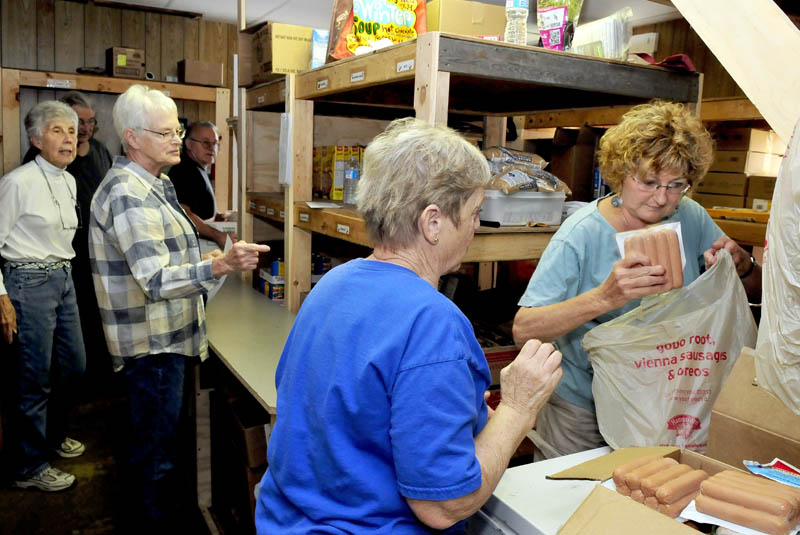 Interfaith Food Pantry volunteers in Fairfield work in a cramped room, filling requests for food on Thursday. A $25,000 pledge in matching funds made recently will help in the goal of $100,000 for a larger facility. From left are Louise O'Brien, Shirley Fenlason, Kathy Keup and Arlene Toulouse.