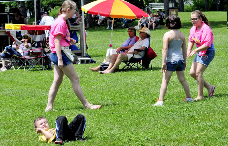 Bryce Whitman tries his hand at break-dancing as Kayla Goggin, left, and Bayleigh and Abi Thibodeau dance to a live band during the Winslow Family Fourth of July celebration on Sunday.