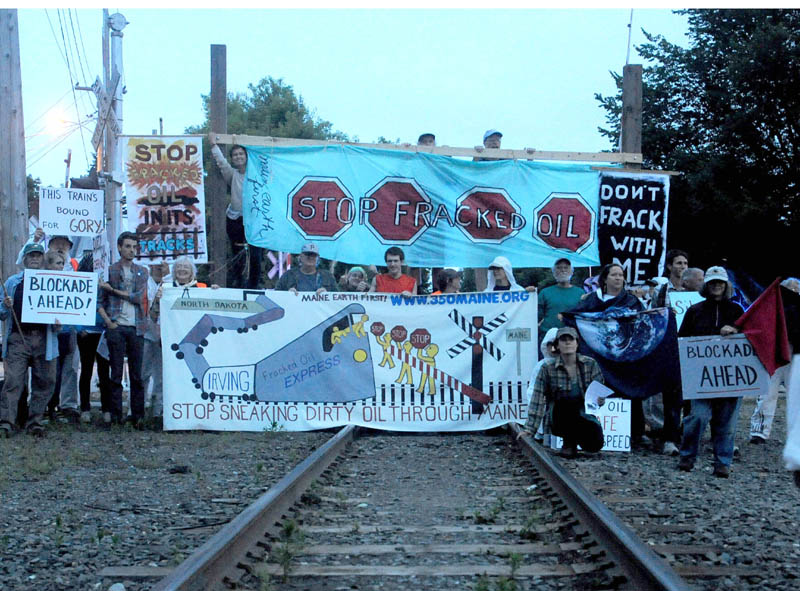 Protesters from 350 Maine block the railroad crossing at Lawrence Avenue in Fairfield Thursday night, to protest the transport of fracked oil.
