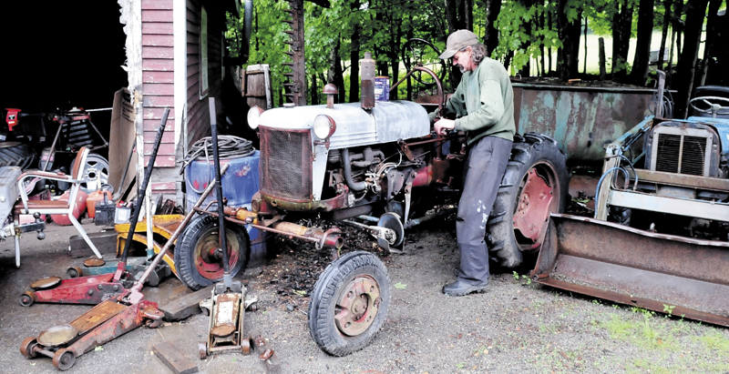 Keith Melancon fires up his older model tractor at his Town Farm Road home in Farmington. Melancon said people have complained about the vehicles and equipment on the property.