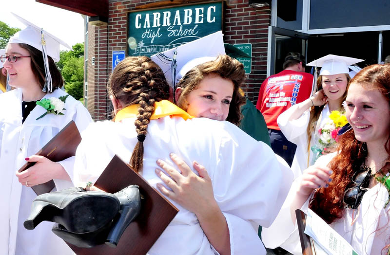 Carrabec High School graduates Michaela Forsten, facing camera, hugs Courtney Frost after graduation ceremonies in North Anson on Sunday.