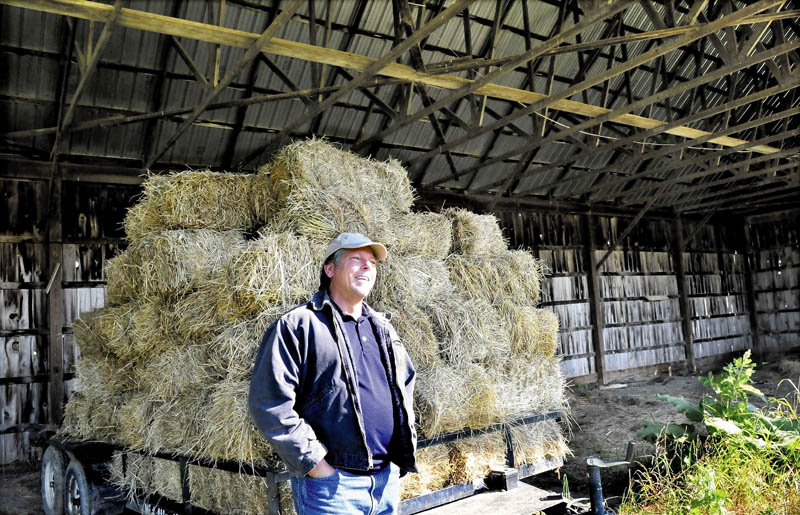 Richard Hopper, president of Kennebec Valley Community College, speaks beside a hay wagon in an unused barn at the Alfond campus in Hinckley on Wednesday. The section, in one of three barns, will be used to store farm equipment, while another section will have labs and classrooms for sustainable agriculture courses.
