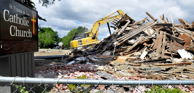 Workers with Danley Demolition have reduced the St. Francis de Sales Catholic Church in Waterville to a pile of rubble on Tuesday. The church and two other nearby buildings have been torn down to make way for a housing development.