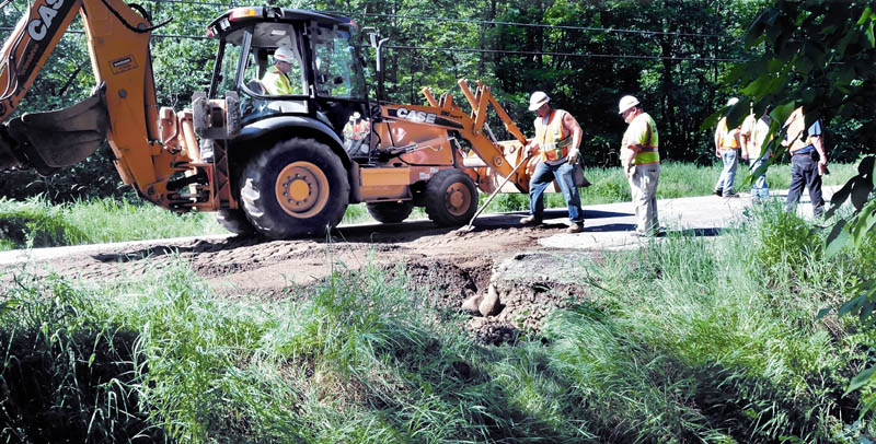 Maine Department of Transportation workers finish repairing a section of Route 148 in Industry Sunday morning. A worker said a heavy rainstorm Saturday night washed out a culvert, forcing officials to close the roadway. Road shoulders and gravel driveways in the area were also washed out.