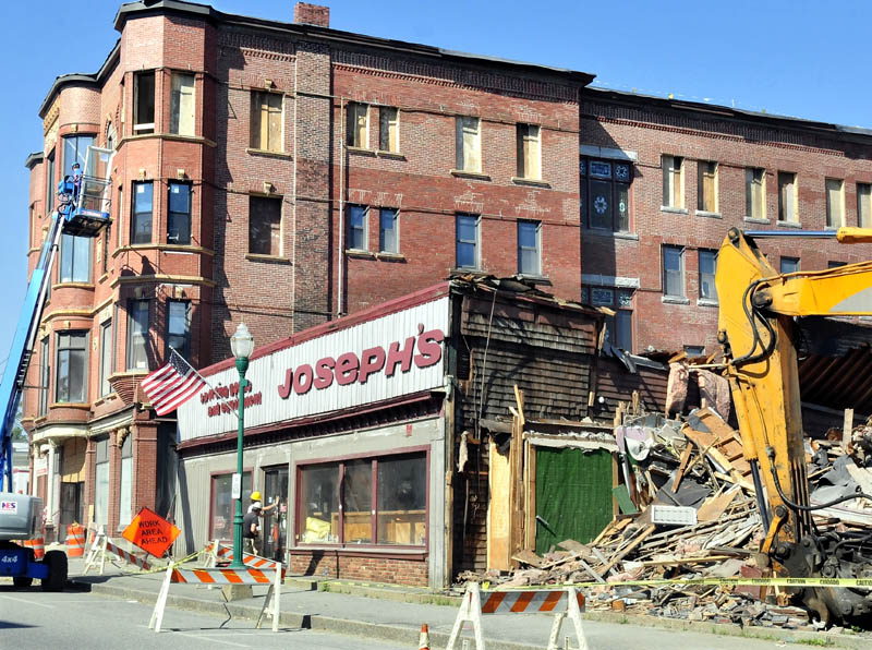 Crews tear down the former Joseph's Sporting Goods store as workers restore the Gerald Hotel on Main Street in Fairfield on Thursday.