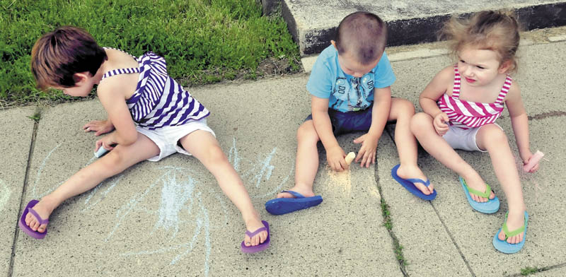 From left, Lakoda Perkins, Michael Perkins and Kailynne O'Neil added some color and shapes with chalk to a drab sidewalk in Waterville on Sunday.