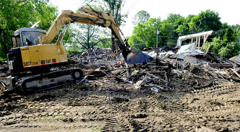 Workers this week break up the remaining sections of an apartment house on Main Street in Unity that was destroyed by fire in March. The lot will be covered with dirt and seeded until a decision is made on developing the lot, according to owner Ralph Nason Sr.