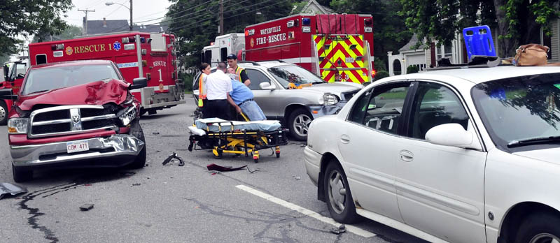 Rescue workers bring an injured man to an ambulance following an accident involving three vehicles in Waterville on Sunday. Waterville police Sgt. Dan Goss said the crash on Main Street, near Eustis Parkway, apparently was caused by driver inattention. Two people were taken to the hospital complaining of neck and back pain, but there were no serious injuries, according to Goss.