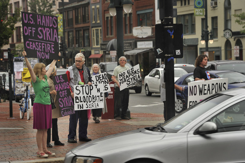 Displaying hand-made signs, demonstrators gather on a corner of Portland’s Congress Square, Friday, to protest U.S. involvement in the war in Syria.