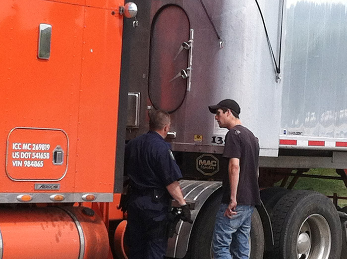 A member of the Maine State Police commercial vehicle inspection unit talks to the driver, name unknown, of the tractor-trailer police believe was involved in the fatal accident in Hanover on Friday.