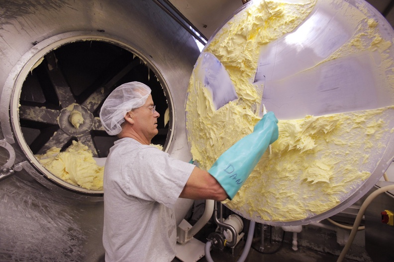 Daniel Patry scrapes butter off the door to a mixer at Kate's Homemade Butter in Old Orchard Beach in 2011. The butter gets a mention in a new Adam Sandler comedy.