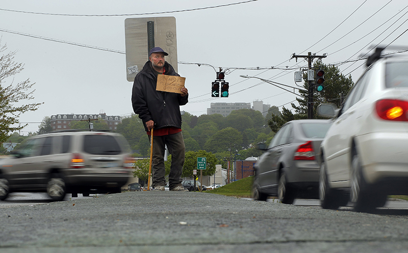 In this file photo, Don Dietz, 48, panhandles for change in the median at the corner of Franklin Street and Marginal Way Friday, May 24, 2013.