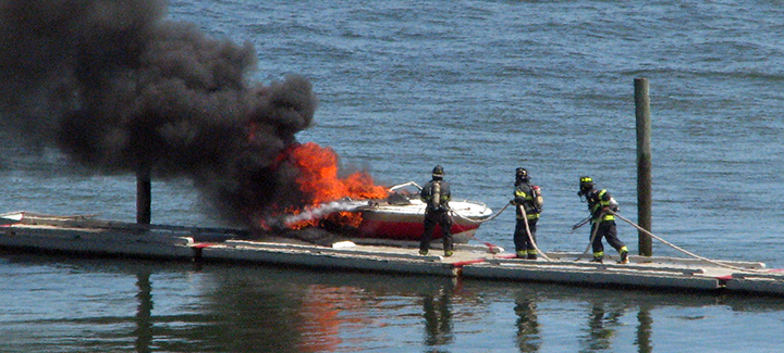 Firefighters extinguish a boat fire at East End Beach in Portland on Friday.