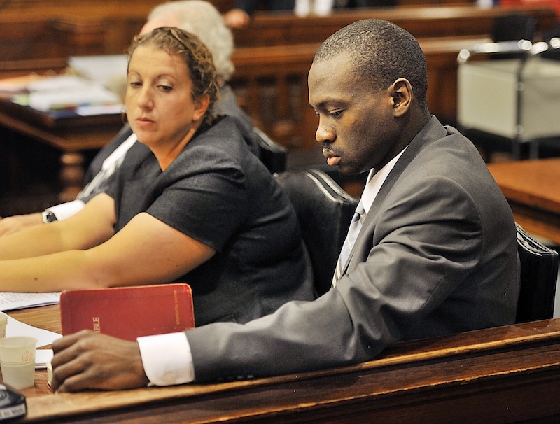 Assistant defense attorney Tina Nadeau looks on as Eric Gwaro, accused of beating a woman and causing her permanent brain damage, looks at his Bible on Friday, July 26, 2013. Friday was the last day of testimony and closing arguments in Gwaro's trial.