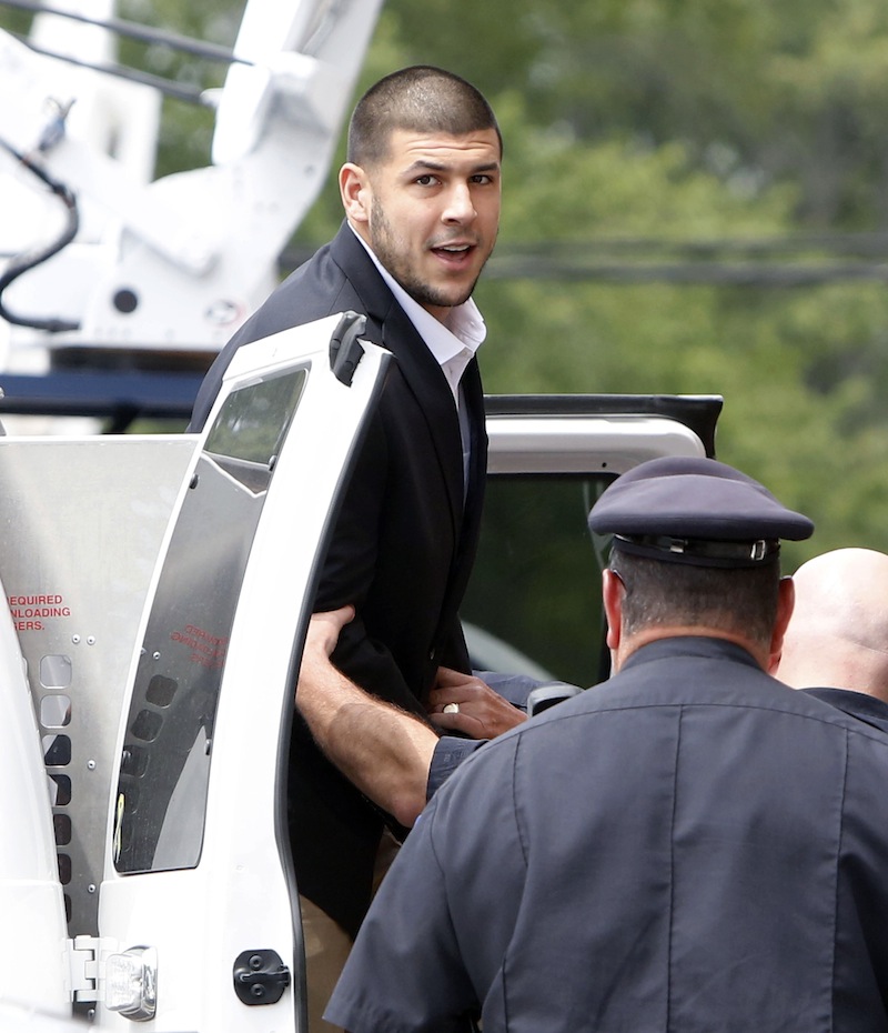 Former New England Patriots NFL football tight end Aaron Hernandez is led out of a van as he arrives for his probable cause hearing at Attleboro District Court on Wednesday in Attleboro, Mass. Newly released surveillance photos show former New England Patriot Aaron Hernandez holding what authorities say appears to be a gun, shortly after his friend was shot to death.
