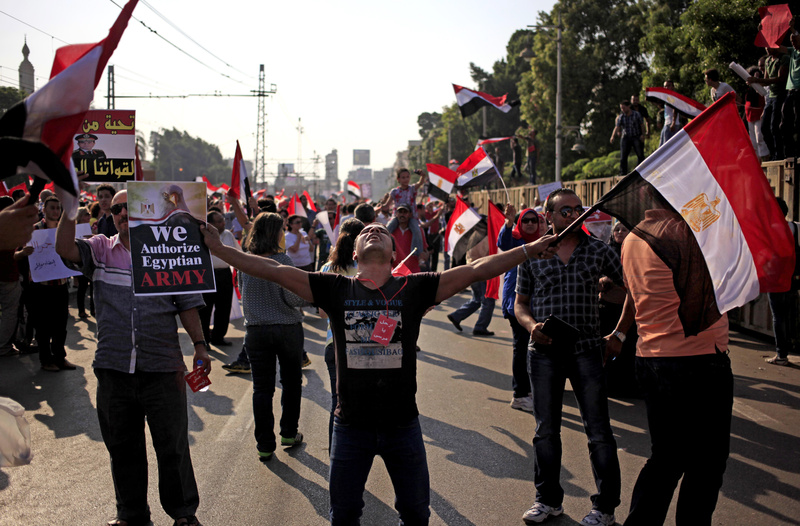 Opponents of Egypt's Islamist President Mohammed Morsi wave national flags during a protest outside the presidential palace in Cairo, Egypt, on Wednesday.