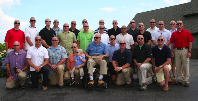 President George H.W. Bush, center, dons trademark sunglasses to pose with a Secret Service group after they shaved their heads in support of a 2-year-old boy being treated for leukemia, left of Bush. This photo was shared on Twitter by Jim McGrath, Bush's spokesman.