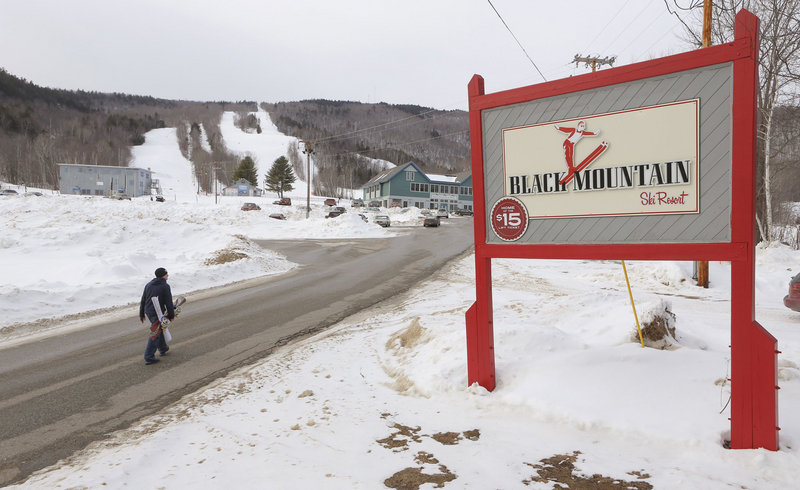 A snowboarder walks up the main access road to Black Mountain in Rumford in this January 11, 2013 file photo. The ski area will remain open after $125,000 was raised in three weeks.
