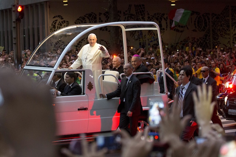 Pope Francis waves from his popemobile as he made his way into central Rio de Janeiro, Brazil, Monday. The pontiff arrived for a seven-day visit in Brazil, the world's most populous Roman Catholic nation. During his visit, Francis will meet with legions of young Roman Catholics converging on Rio for the church's World Youth Day festival.
