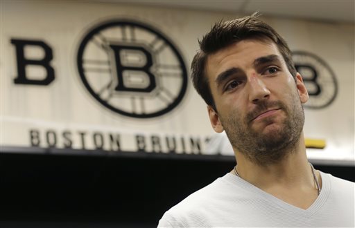 Boston Bruins center Patrice Bergeron talks with reporters in the team locker room on July 2, 2013, in Boston. Bergeron played through multiple injuries including a broken rib, separated shoulder and hole in his lung during the Stanley Cup Championship.