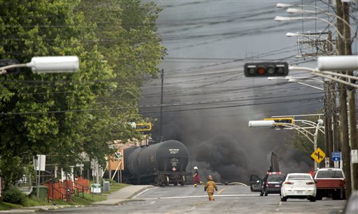 Smoke rises from derailed railway cars that were carrying crude oil in downtown Lac-Megantic, Quebec, on Saturday.