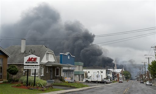 Smoke billows behind buildings in Lac-Megantic, Quebec, hours after a fiery train derailment Saturday.