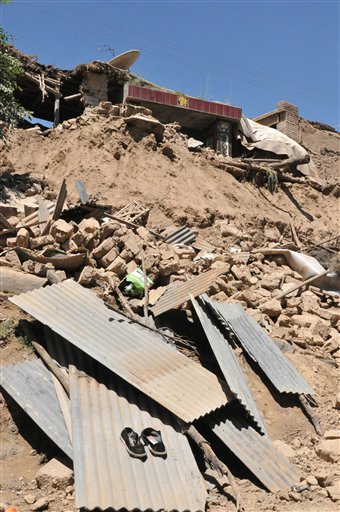 In this photo released by Xinhua News Agency, a damaged house stands in rubble following an earthquake that hit Majiagou Village of Minxian County, northwest China's Gansu Province.