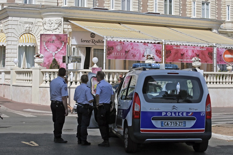Police gather outside the Carlton Intercontinental Hotel in Cannes, in southern France, where a staggering $136 million worth of jewels and diamonds were stolen Sunday.