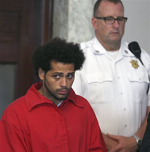 Carlos Ortiz, left, stands in Attleboro District Court for his arraignment on weapons charges, Friday, June 28, 2013 in Attleboro, Mass. Ortiz was arrested Wednesday in Bristol, Conn., in connection with the murder case against former New England Patriots tight end Aaron Hernandez , now charged in the murder of Odin Lloyd. (AP Photo/The Boston Globe, George Rizer, Pool) carlos oritiz arraignment