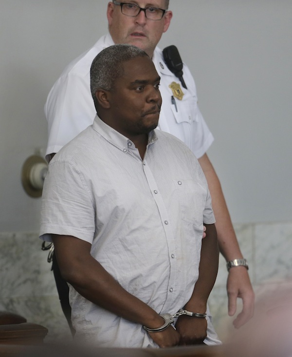 Ernest Wallace, of Miramar, Fla., stands in handcuffs in Attleboro District Court, in Attleboro, Mass., during his arraignment, Monday, July 8, 2013. Wallace, who pleaded not guilty, is facing an accessory to murder charge in the case involving former New England Patriots tight end Aaron Hernandez and has been ordered held without bail. (AP Photo/Steven Senne, Pool)