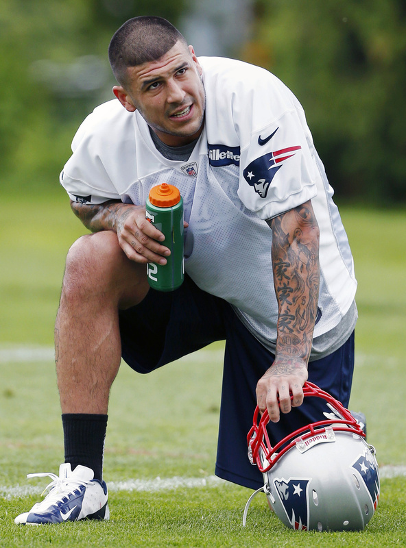 New England Patriots' Aaron Hernandez kneels on the field during NFL football practice in Foxborough, Mass., in May.