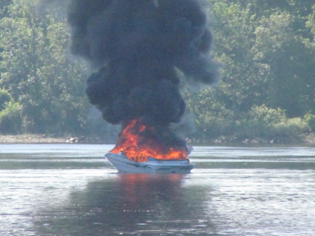 A boat burns on the Kennebec River in Pittston following an explosion on Friday.